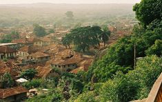 an old village is shown in the distance with lots of trees and houses on it