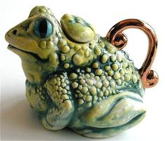 a ceramic frog sitting on top of a white table