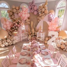 a table set up with pink and gold balloons