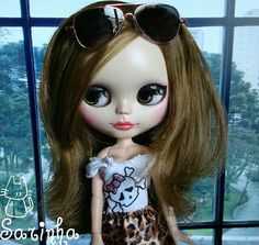 a close up of a doll wearing sunglasses and a dress with leopard print on it