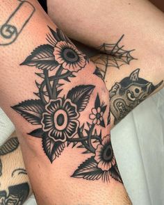 a woman's legs with tattoos and flowers on them