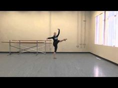 a young woman is practicing ballet in an empty room