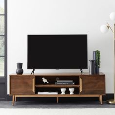 a flat screen tv sitting on top of a wooden entertainment center in a living room