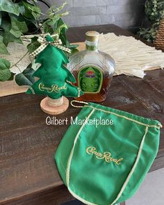 a bottle of gin on top of a table next to a green bag and some plants