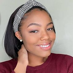 a woman wearing a headband smiling at the camera with her hand on her shoulder