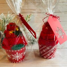 two christmas baskets with red and white flowers in them, one is wrapped in clear cellophane