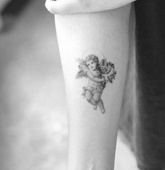 an angel tattoo on the right arm and leg, with flowers in her hand next to it