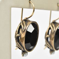 Faceted black glass stone Bronze components Pearl accents Locking french wire earring Earrings measure 1" long Made by Extasia Designer Jewelry. Goldmakers Jewelry Mission Statement Goldmakers Jewelry creates and curates a comprehensive selection of artfully designed hand-crafted jewelry. We aspire to offer the jewelry enthusiast access to affordable classics as well as fresh innovative designs. Antique Black Earrings For Formal Occasions, Antique Brass Jewelry With Lever Back Ear Wires, Antique Black Drop Earrings, Black Antique Drop Earrings, Antique Black Dangle Jewelry, Nickel-free Metal Crystal Earrings For Formal Occasions, Black Drop Earrings With French Hook, Formal Nickel-free Metal Crystal Earrings, Elegant Handmade Black Clip-on Earrings