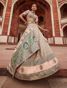 This stunning bandhani banarasi lehenga features a striking jamavar panel that enhances its beauty. The embroidered blouse showcases a sweetheart neckline and intricate cutwork detail on the hem, adding a touch of romance. Paired with a shimmering tissue dupatta featuring a gota scalloped border, this ensemble exudes elegance. The waist belt, adorned with mirrors, brings a hint of sparkle, making it a perfect choice for festive celebrations. Flare Lehenga, Butti Embroidery, Aditi Gupta, Bandhani Lehenga, Embroidery Zardozi, Princess Cut Blouse, Zardozi Embroidery, Blue Lehenga, Padded Blouse