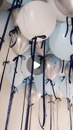 balloons are tied to the ceiling with blue ribbons and bowknots on them