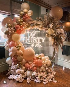 an arrangement of balloons and flowers in front of a sign that reads thirty the birthday girl