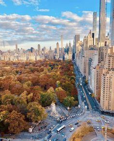 an aerial view of a city with tall buildings and lots of trees in the foreground