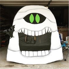 a large inflatable monster with green eyes and fangs on it's face