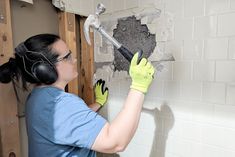 a woman with headphones and ear phones working on a wall