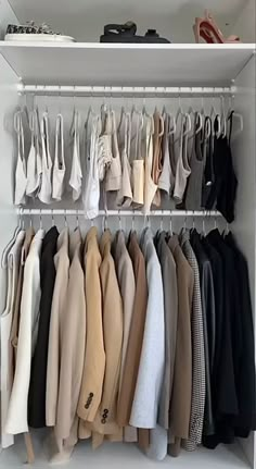 a white closet filled with lots of clothes