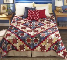 a bed with a red, white and blue quilt on it