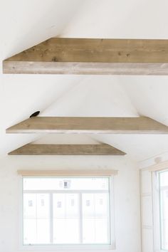 an empty room with white walls and wooden beams