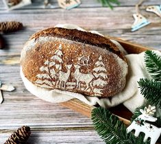 a loaf of bread sitting on top of a wooden table next to pine cones and christmas decorations