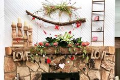 a fire place with decorations on the mantle and candles in front of it that says love