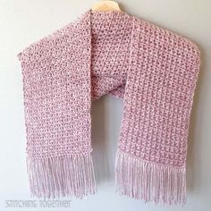 a pink and white scarf hanging on a wall