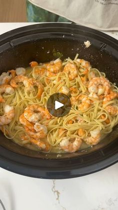 a pan filled with pasta and shrimp on top of a stove