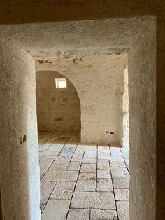 an open door leading into a room with white walls and tile on the floor,