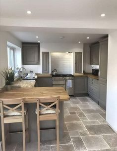 a kitchen with grey cabinets and tile flooring