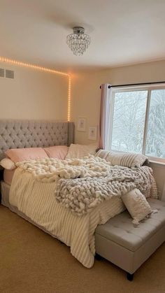 a bedroom with a large bed and a chandelier hanging from it's ceiling