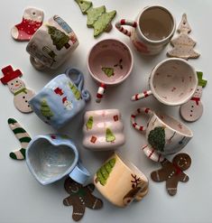 many different cups and saucers are arranged in a circle on a white table top