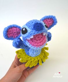 a small crocheted toy is being held by a hand