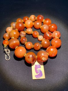 The beautiful orange color carnelian beads necklace from Himalaya Nepal This beads were used in prayer malas and used as jewelry and amulets in ancient times very smooth and shinny surface of this beads because of passage of time and usage of this beads in prayers mala and in necklace The age of this beads are more than 1000 years small size gold color brass beads are used as spacers in the necklace we provide fast and free shipping service to our customers by which can get the items by maximum Traditional Orange Carnelian Beaded Necklace, Hand-strung Orange Carnelian Beaded Necklaces, Carnelian Orange Amulet Necklace, Hand-strung Orange Carnelian Necklaces, Orange Carnelian Necklace In Spiritual Style, Orange Agate Beads For Jewelry Making, Handmade Carnelian Orange Beads, Orange Carnelian Hand-strung Necklace, Orange Carnelian Beads For Spiritual Purposes