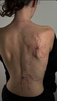 the back of a woman's shoulder with a flower tattoo on her left side