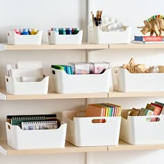 the shelves are filled with books and crafting supplies in white bins on top of each other