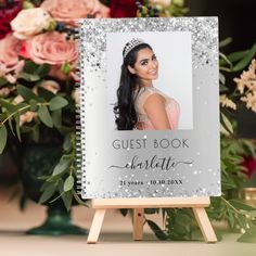 the guest book is sitting on top of an easel with flowers in the background