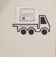 a white wall with a drawing of a truck on it's side and a red box in the middle