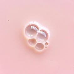 an odd looking object on a pink surface that looks like it has three holes in the middle