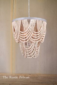 a chandelier made out of beads hanging from a chain on a wooden table