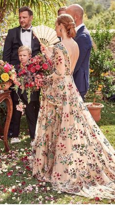 a man and woman standing next to each other in front of a table with flowers on it