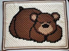 a crocheted teddy bear is shown on a white surface with brown trimmings