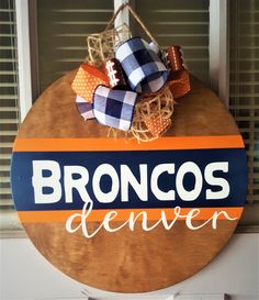 a wooden sign that says bronco's denver hanging from the side of a door