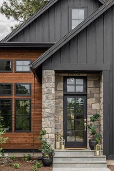 a black and brown house with stone accents