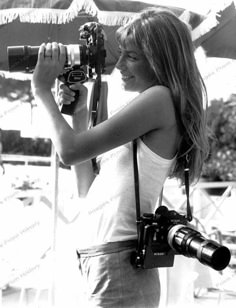 black and white photograph of a woman holding a camera