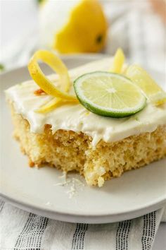 a piece of cake with white frosting and lime slices