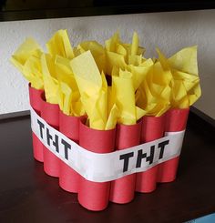 a red and white box with yellow tissue paper in it that says tht on the side