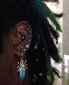 a close up of a person with dreadlocks and piercings on their ears