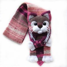 a knitted scarf with a cat on it's side and a pink striped scarf around the neck