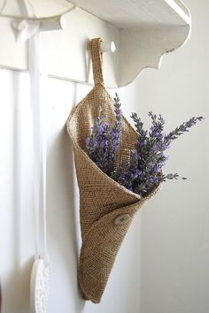 a bunch of lavenders in a burlock hanging from a hook on a wall