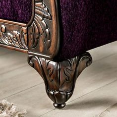 an ornately decorated bed frame with purple velvet upholster and wood flooring