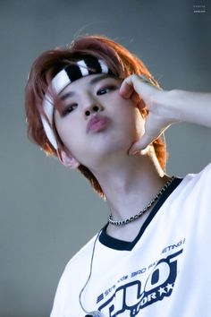 a young man with red hair wearing a white t - shirt and black and white headband