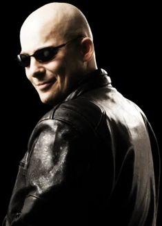 a bald man wearing sunglasses and a leather jacket